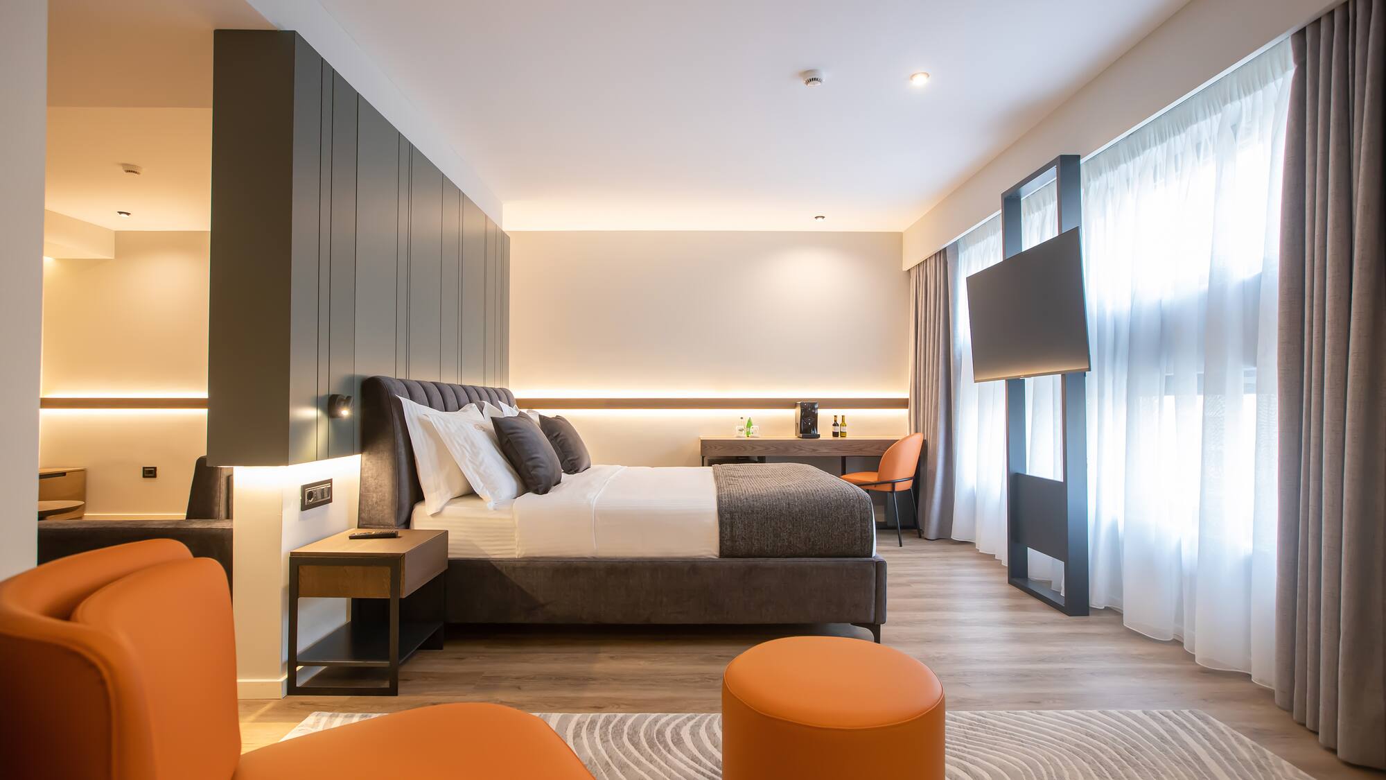 a room with a bed and orange chairs