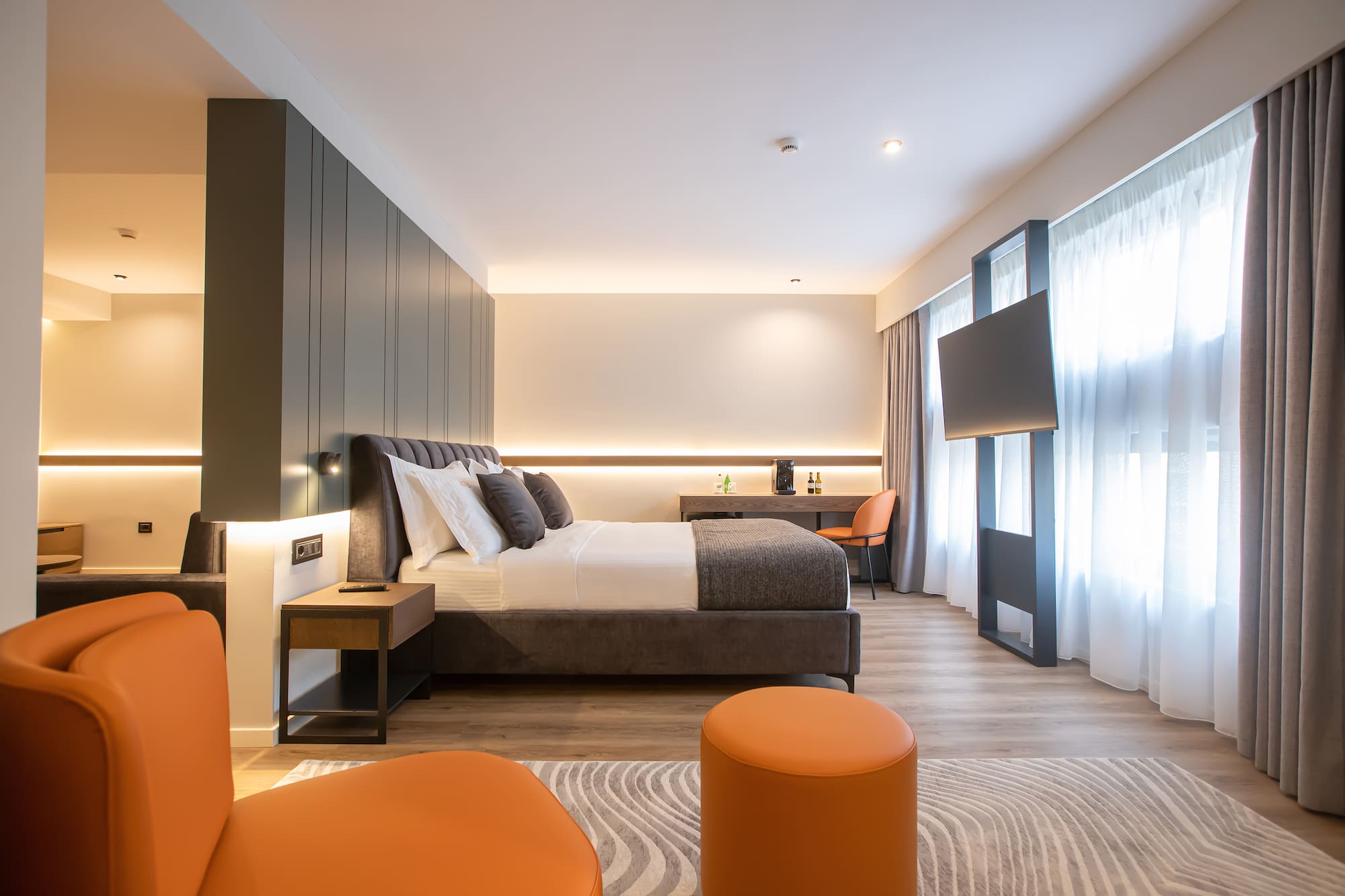 a room with a bed and orange chairs