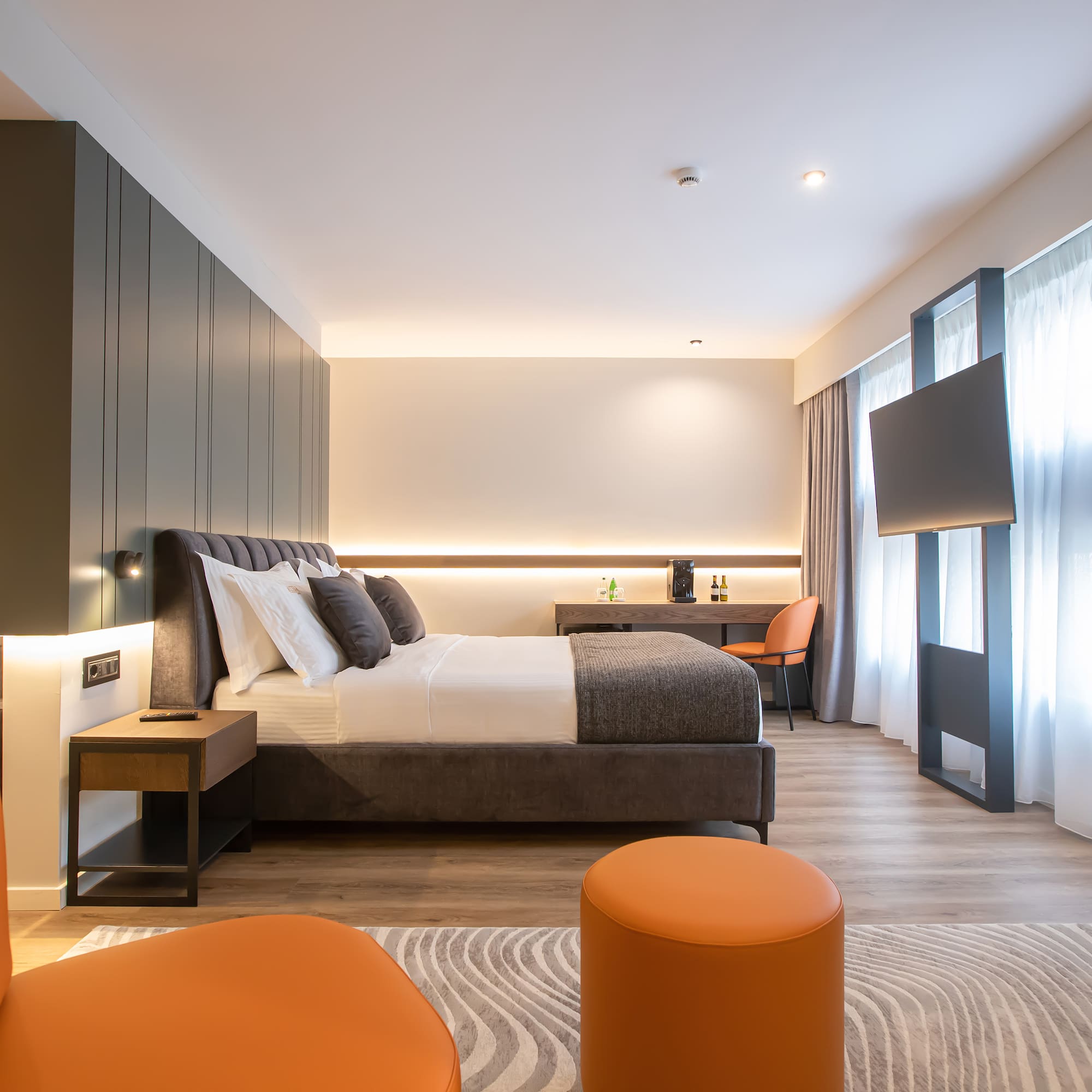 a room with a bed and orange chairs