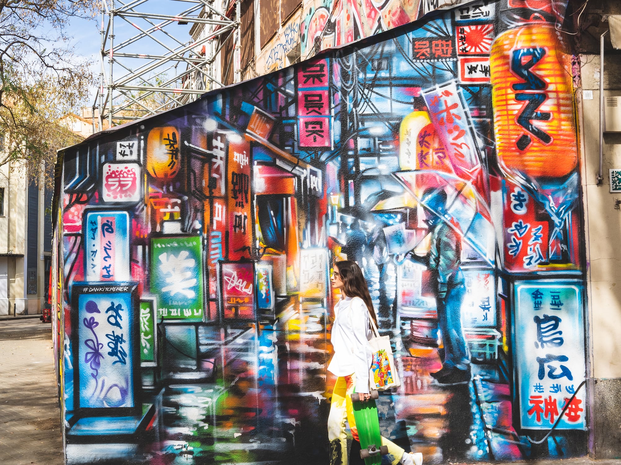 a woman walking in front of a mural