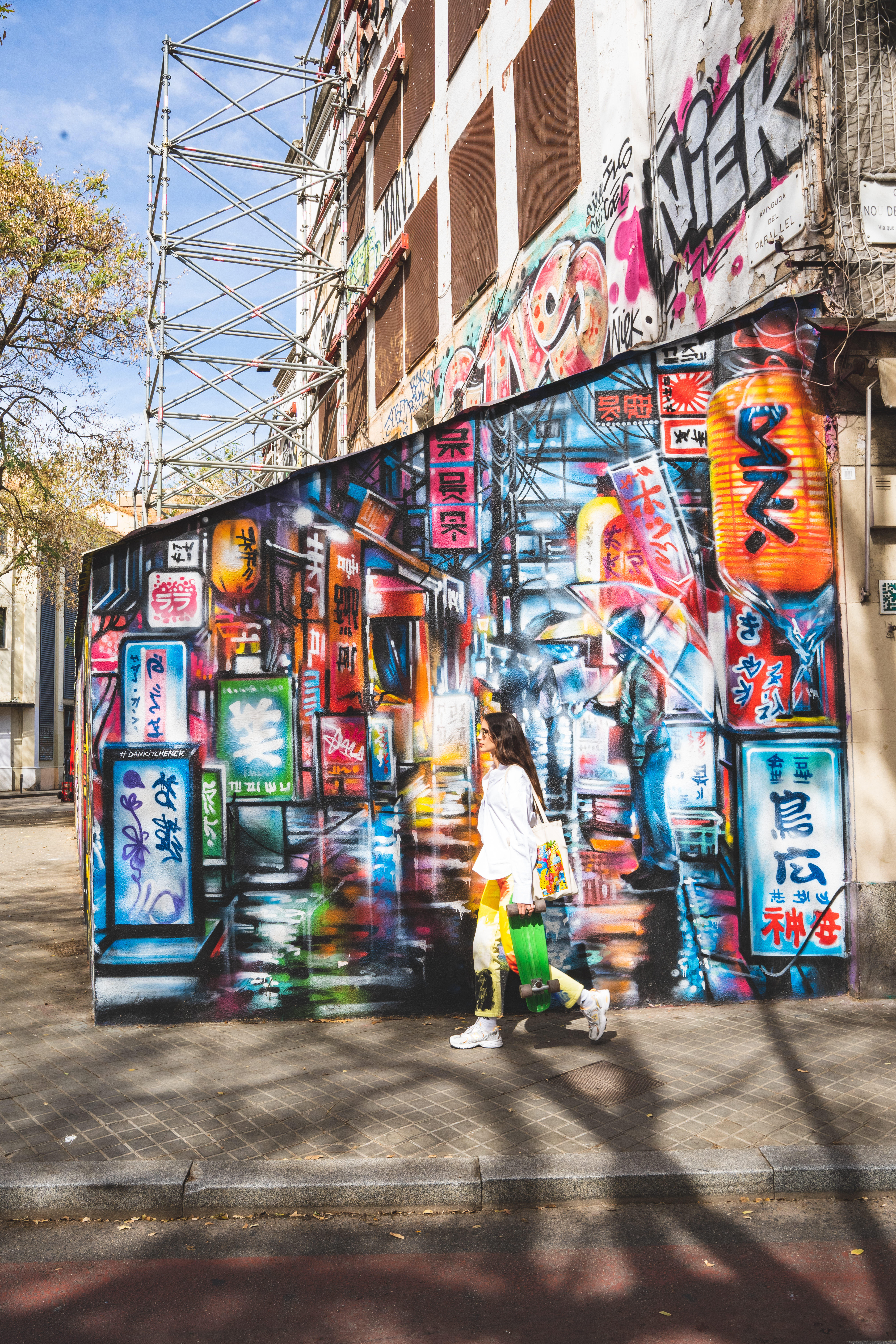 a woman walking in front of a mural