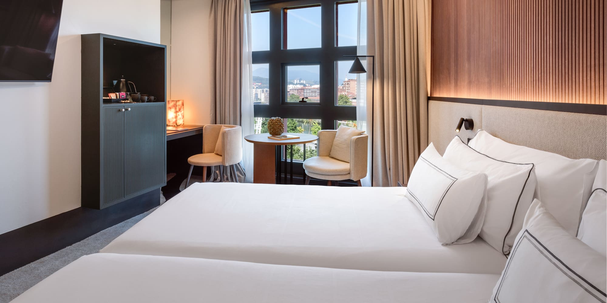 a room with two beds and a table and chairs