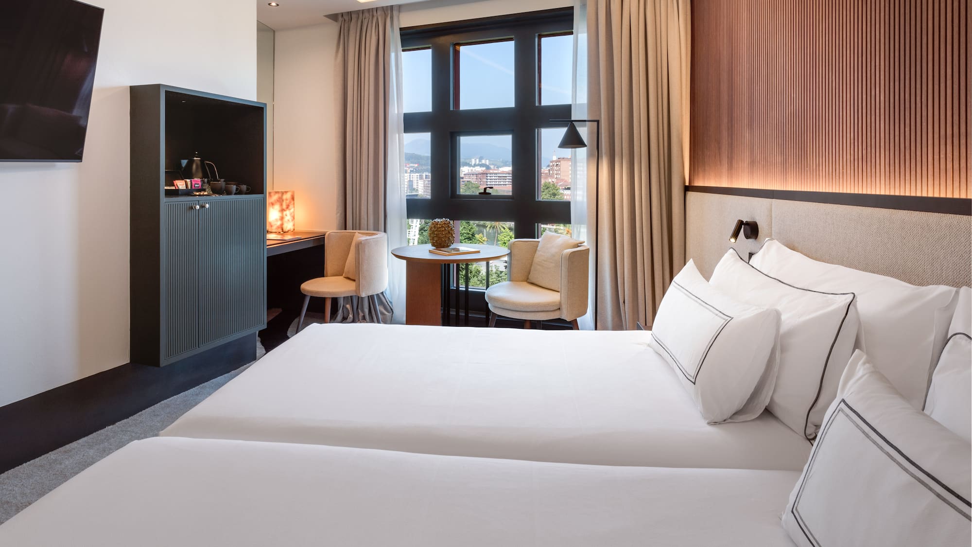 a room with two beds and a table and chairs