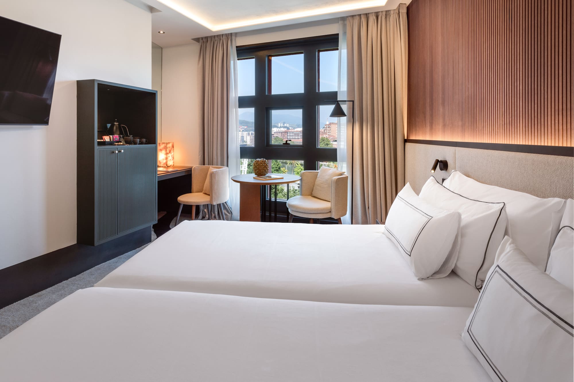 a room with two beds and a table and chairs