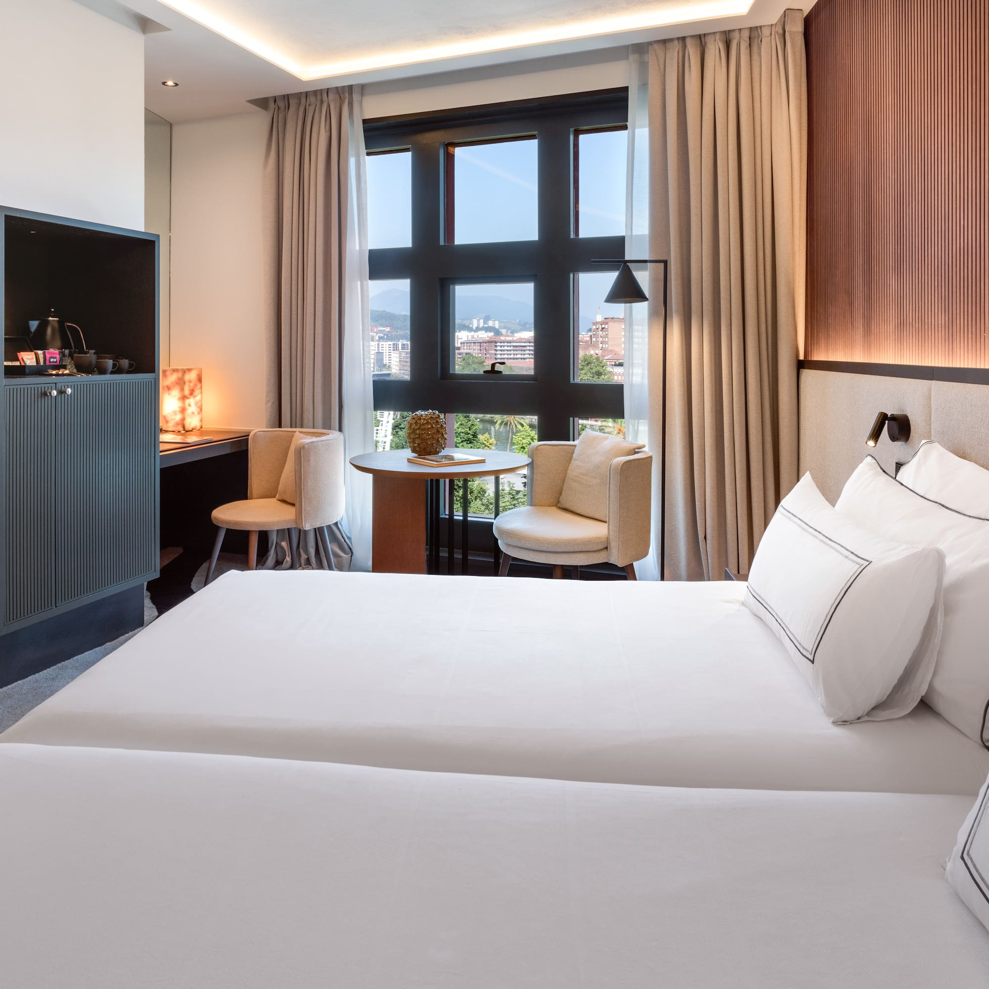 a room with two beds and a table and chairs