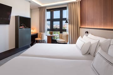 a room with two beds and a table and chairs