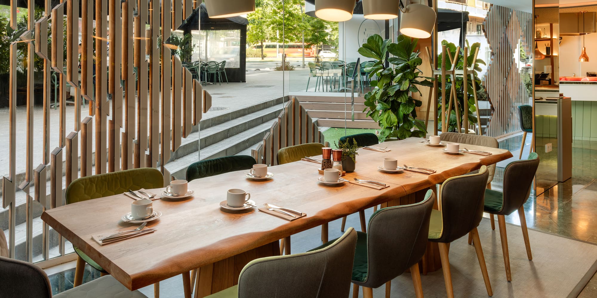 a table with plates and utensils in a room with stairs and trees