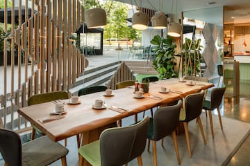 a table with plates and utensils in a room with stairs and trees