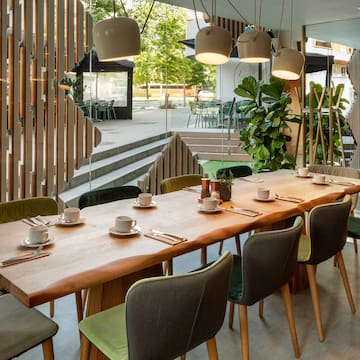 a table with plates and utensils in a room with stairs and trees