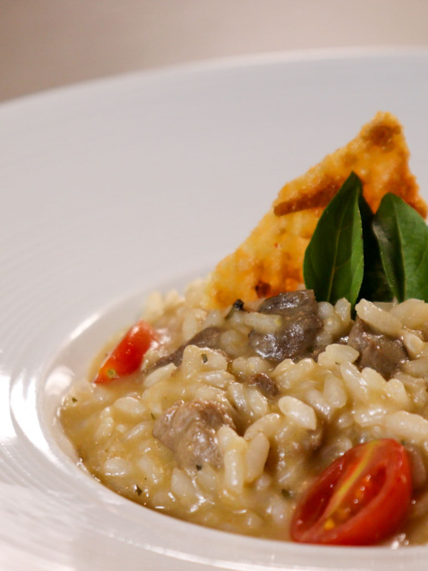 a plate of food with a piece of crispy leaf on top