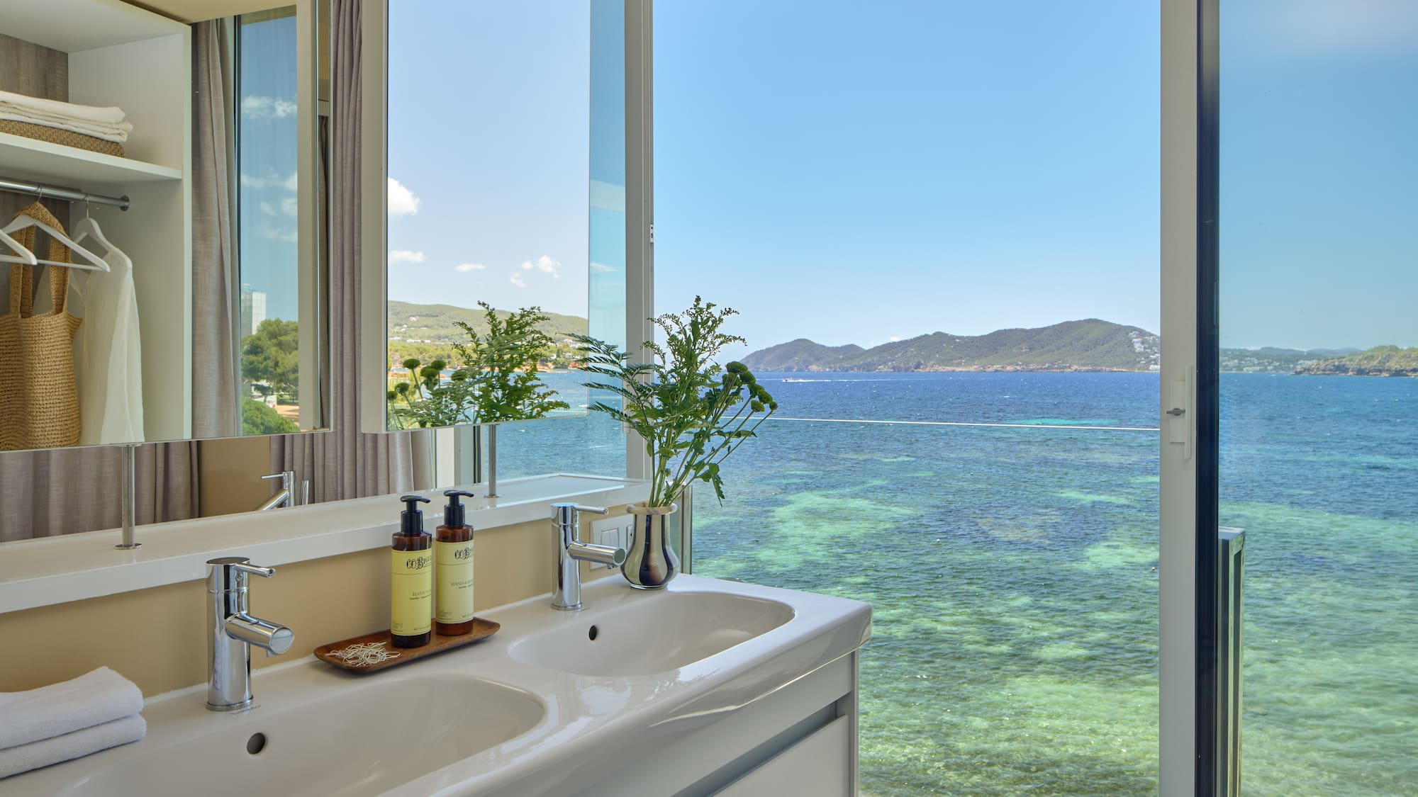 Luxury bathroom with double sinks overlooking the clear blue sea.