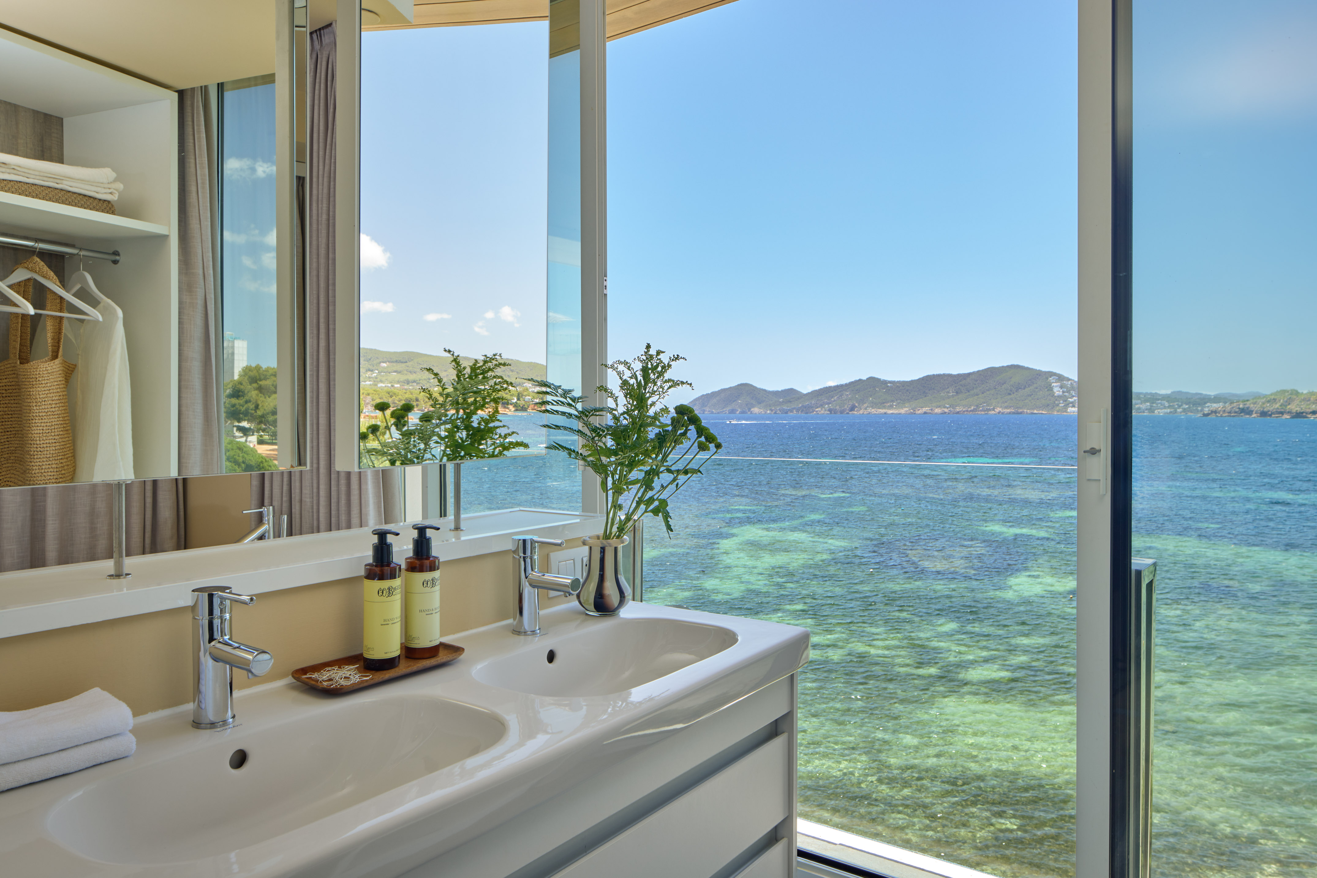 Luxury bathroom with double sinks overlooking the clear blue sea.