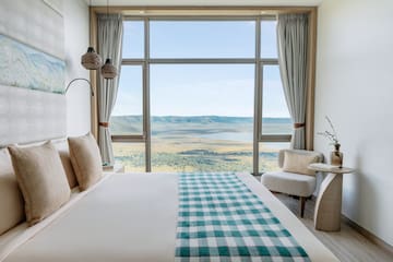 a room with a bed and a view of the valley