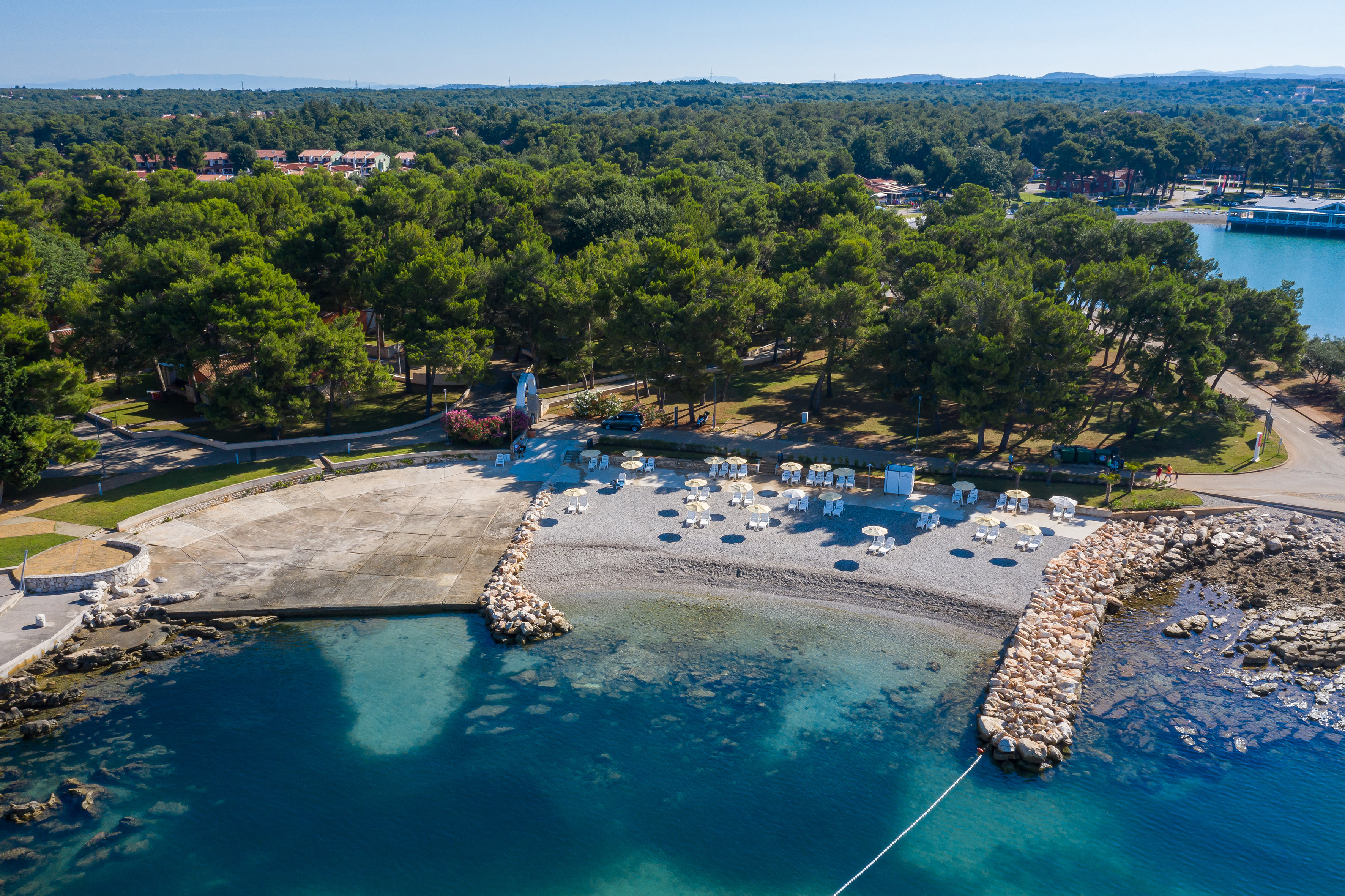 a beach with a rock wall and trees