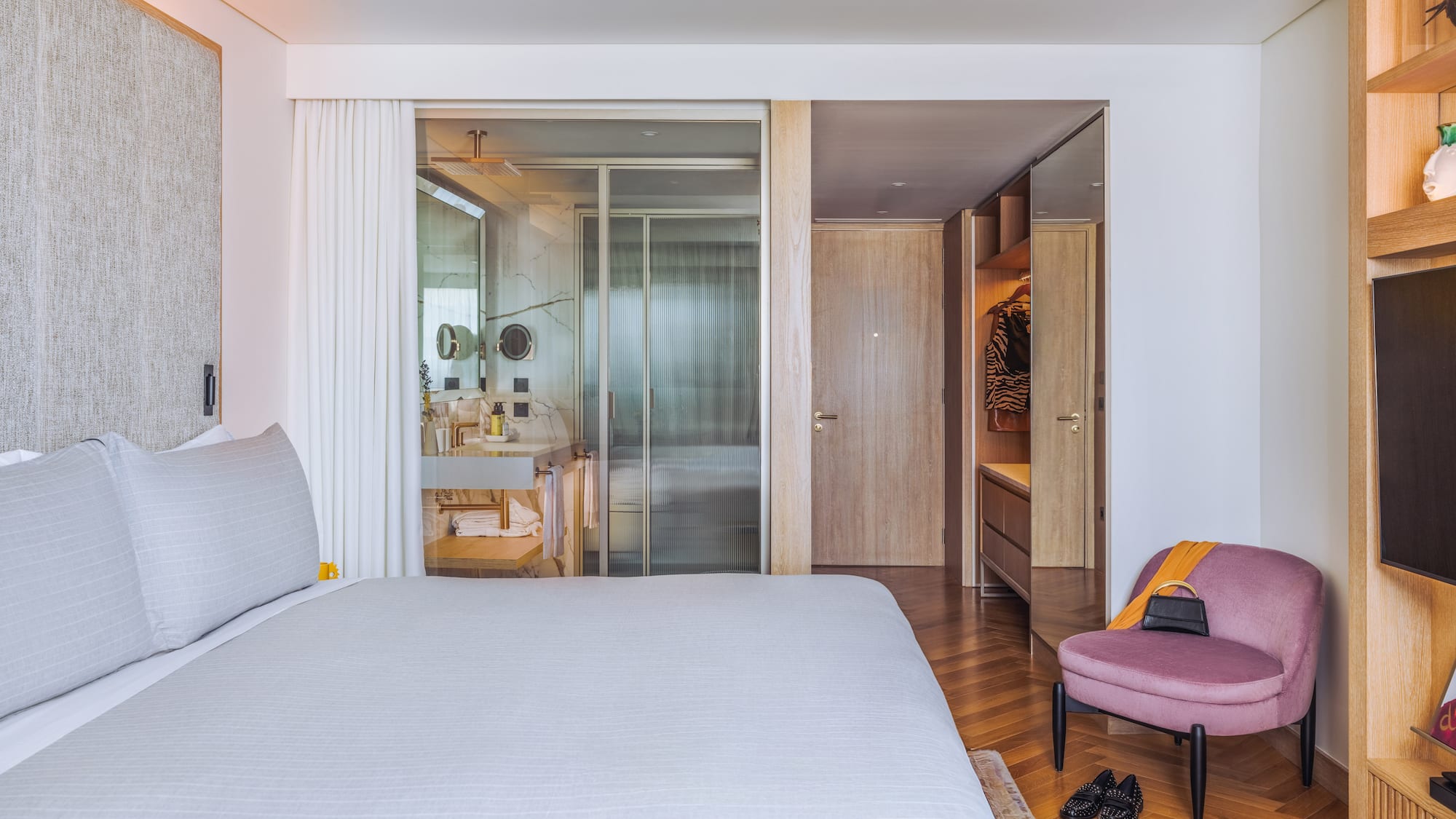 a bedroom with a bed and a pink chair