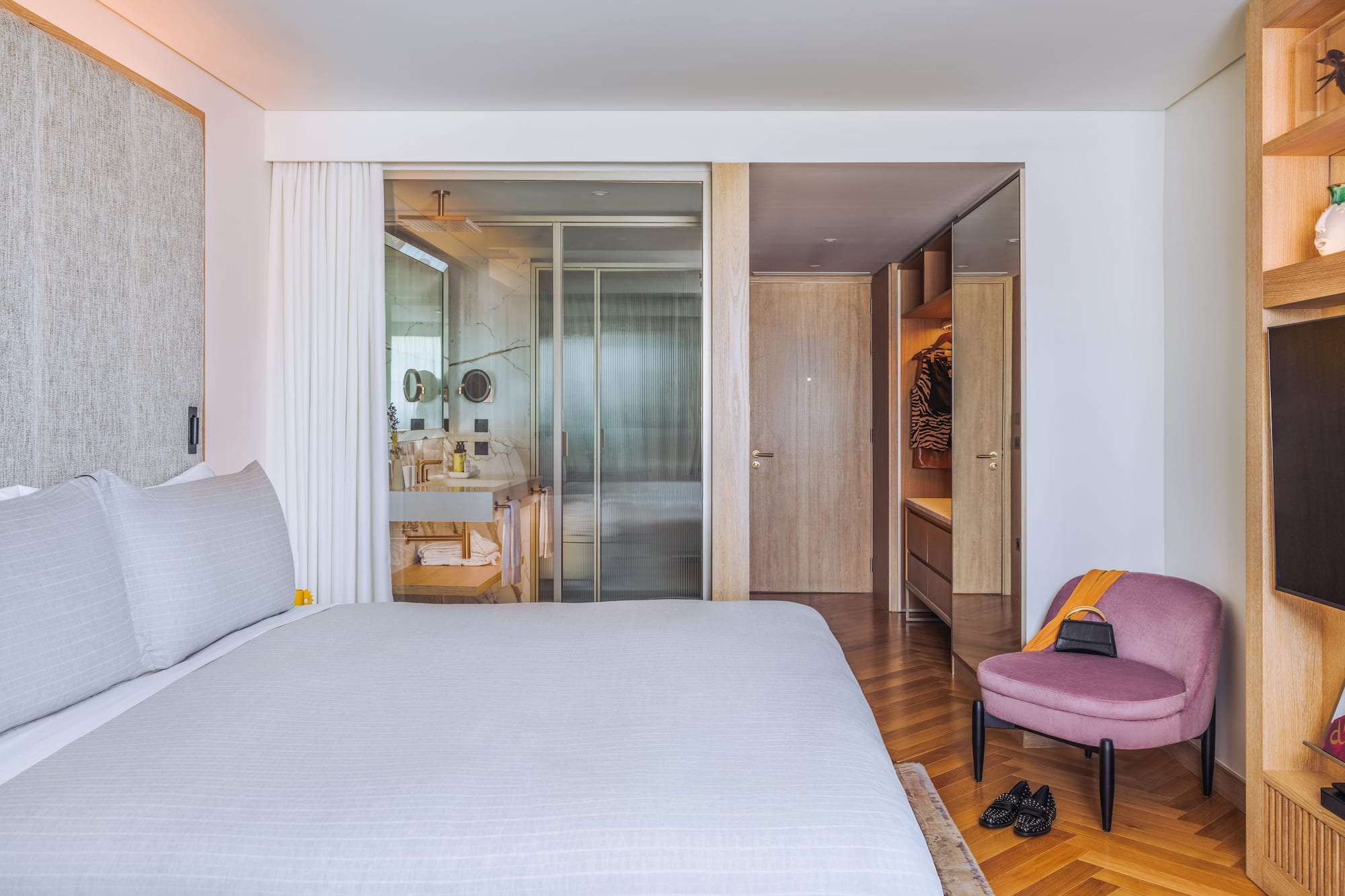 a bedroom with a bed and a pink chair