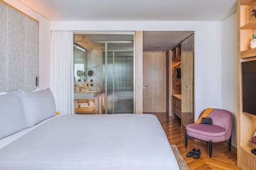 a bedroom with a bed and a pink chair