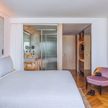 a bedroom with a bed and a pink chair