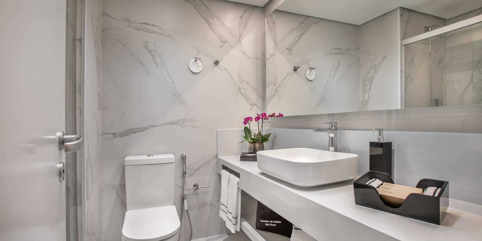 a bathroom with marble walls and a sink and toilet