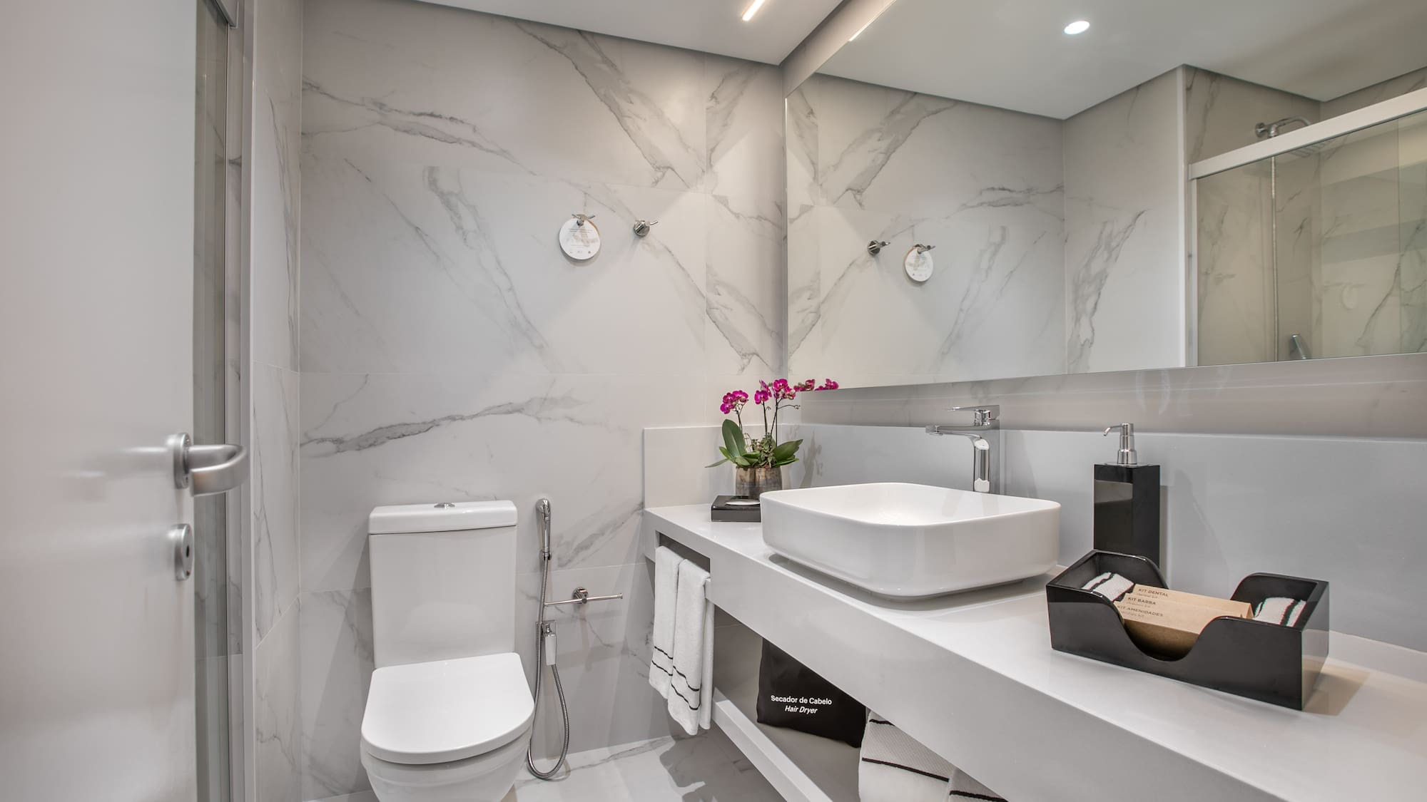 a bathroom with marble walls and a sink and toilet