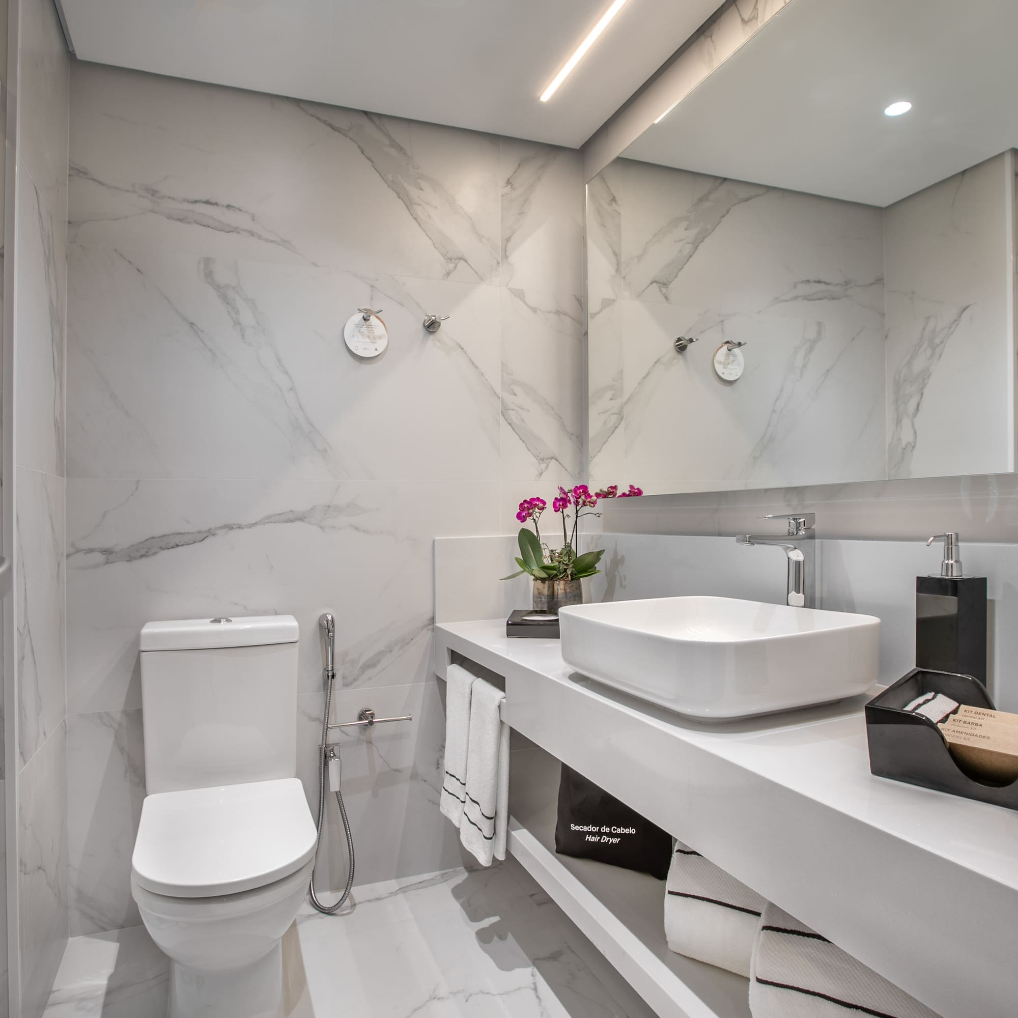 a bathroom with marble walls and a sink and toilet