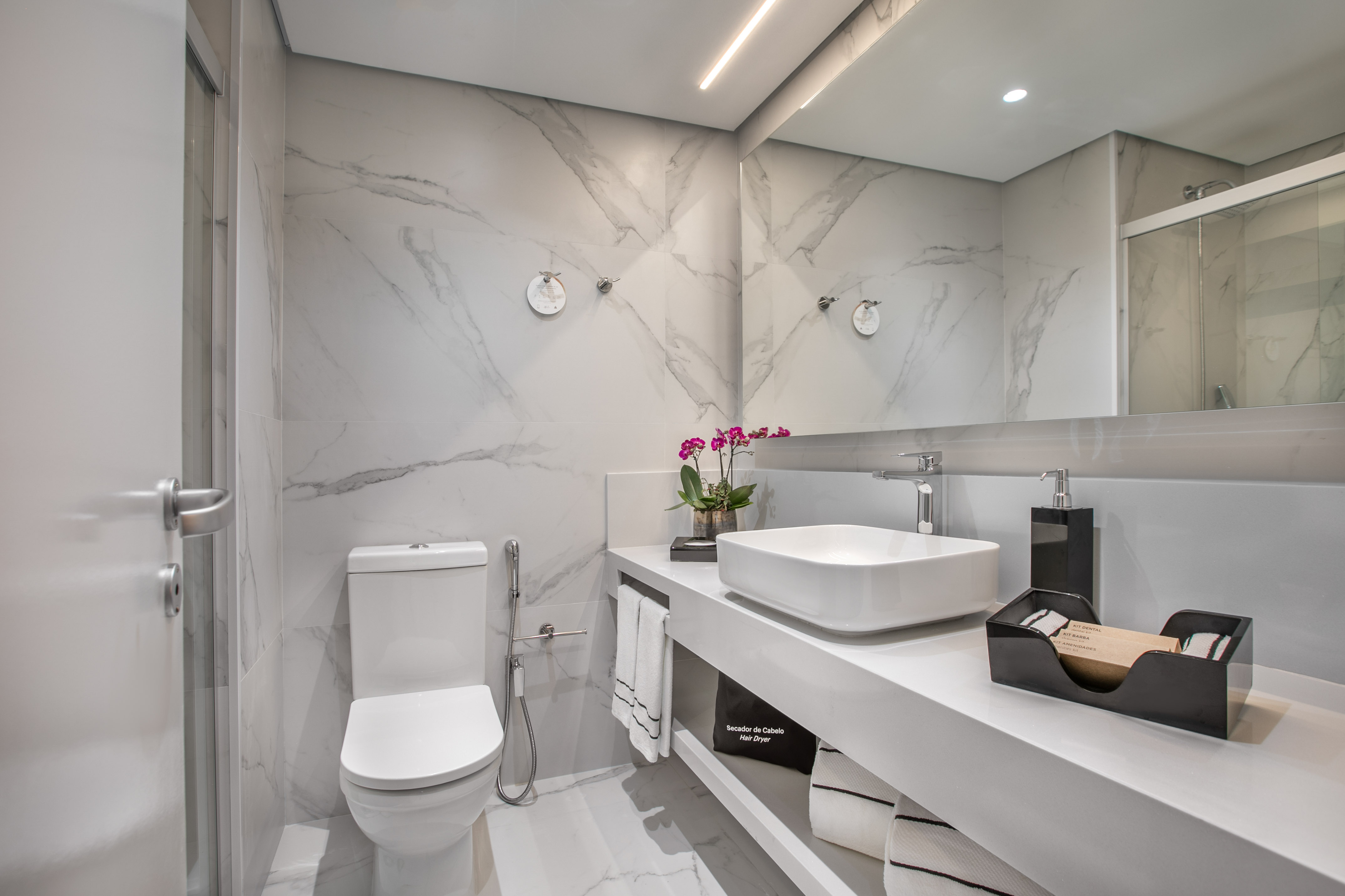 a bathroom with marble walls and a sink and toilet