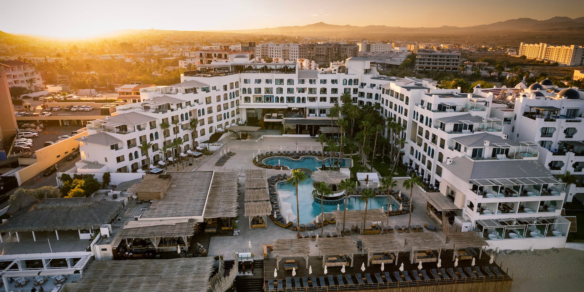 a large white building with a pool and a beach