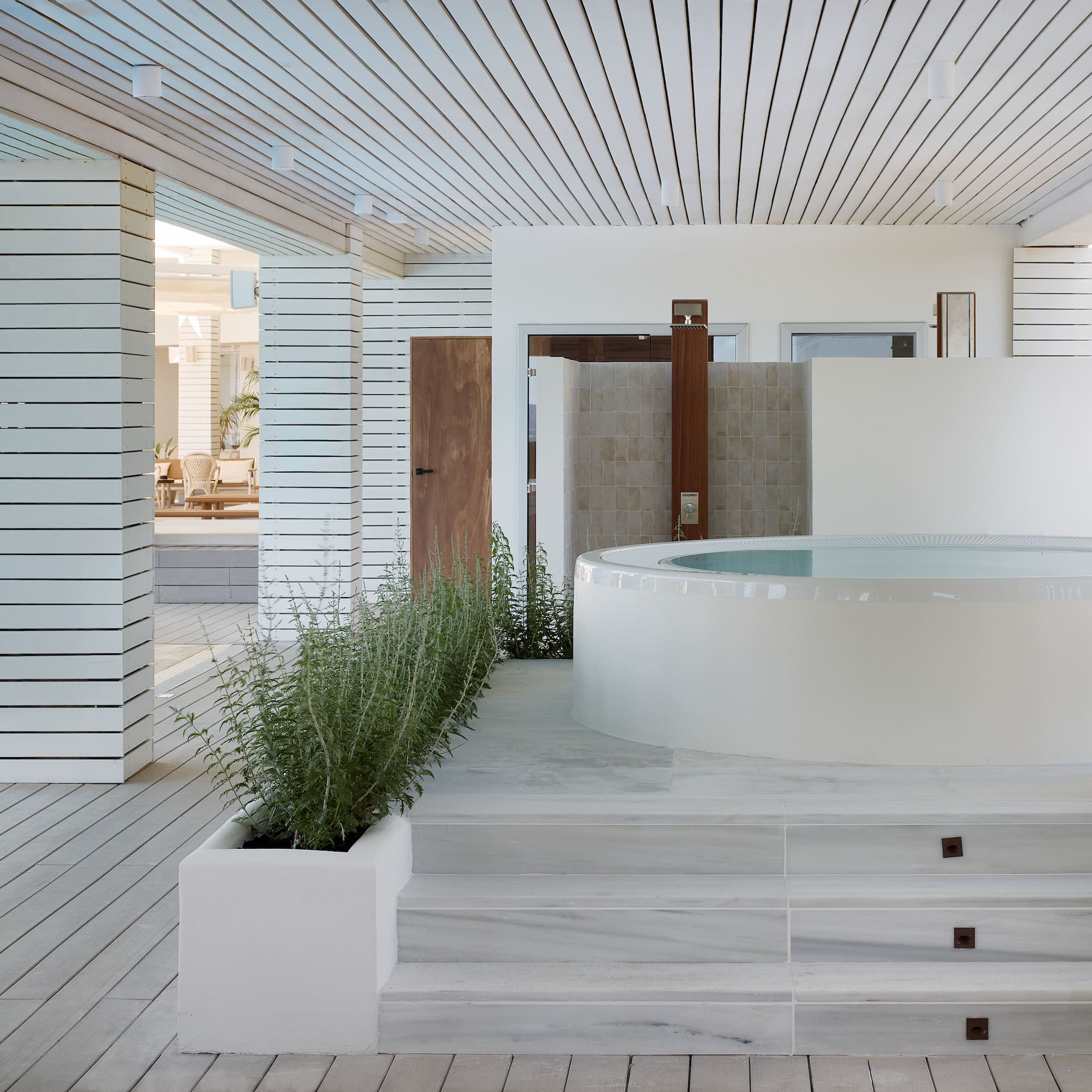 a white room with a hot tub and plants