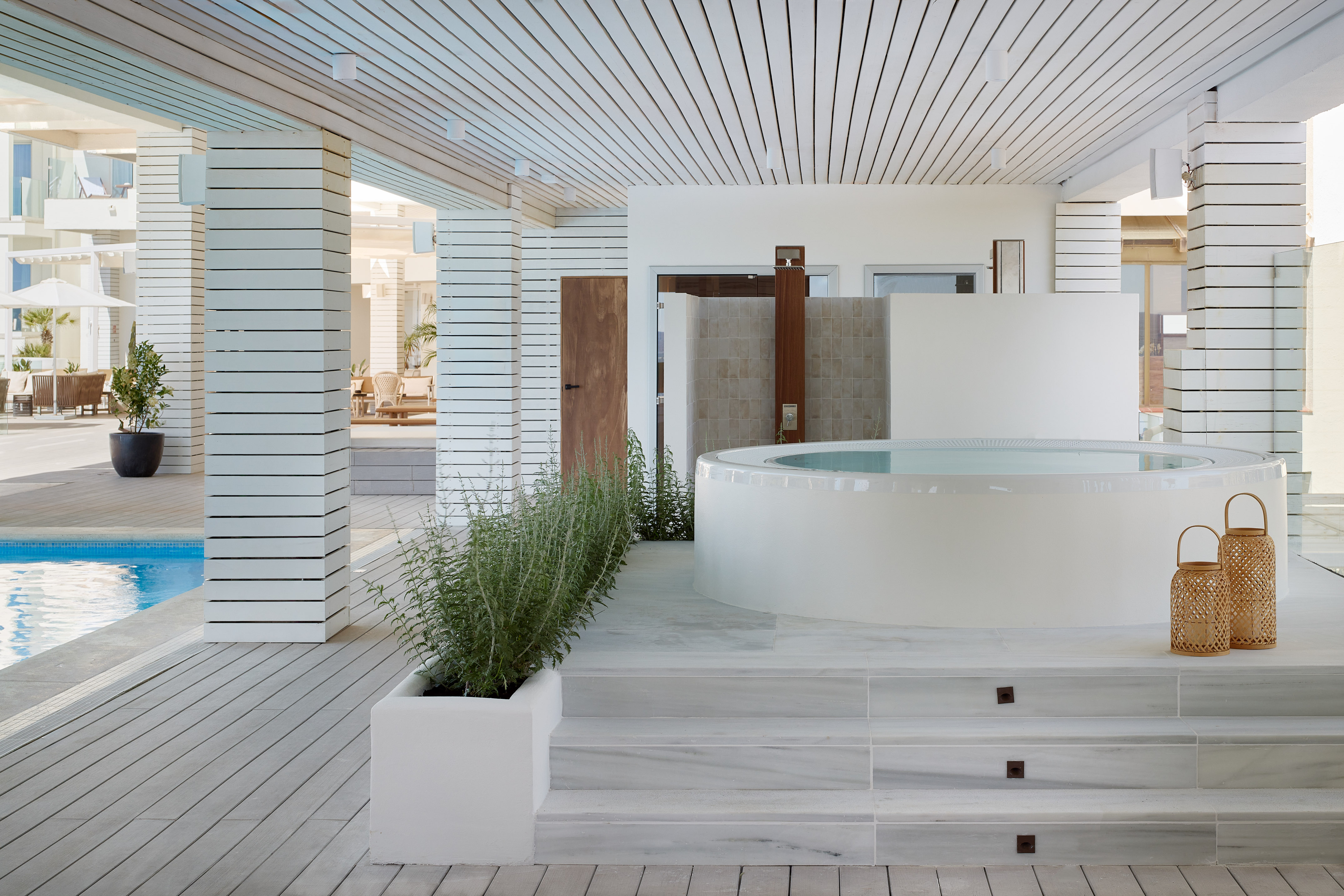 a white room with a hot tub and plants