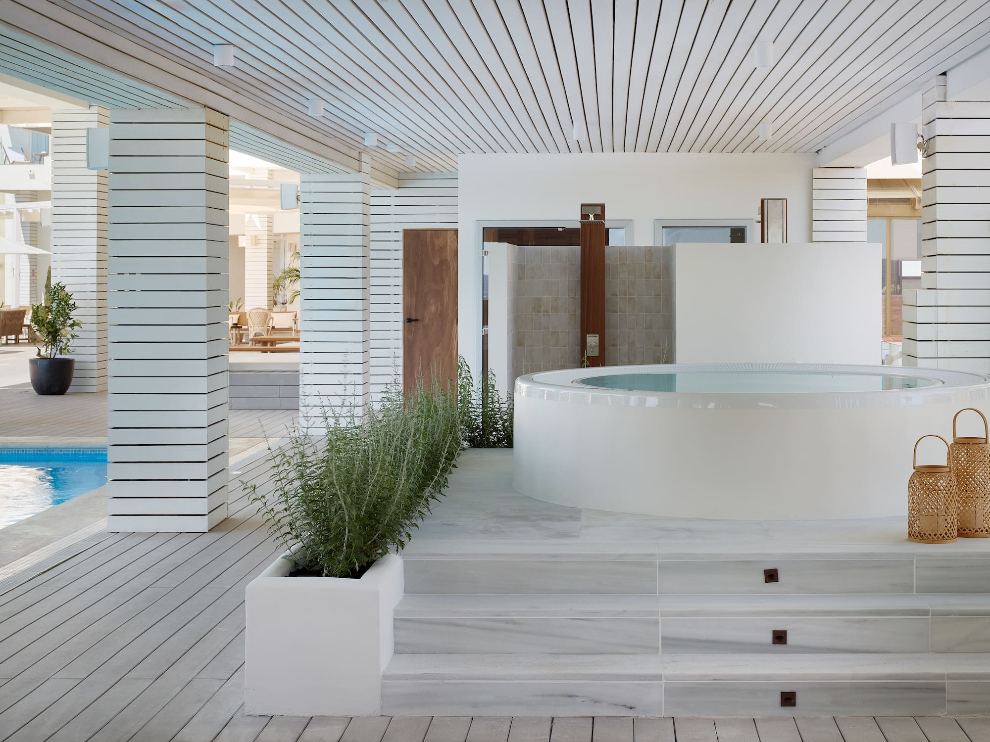 a white room with a hot tub and plants