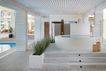 a white room with a hot tub and plants