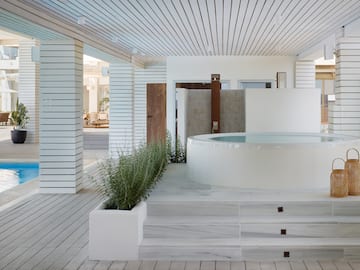 a white room with a hot tub and plants