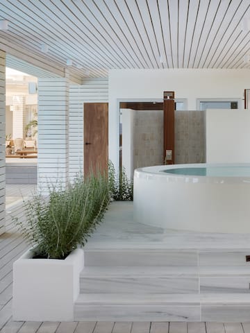 a white room with a hot tub and plants