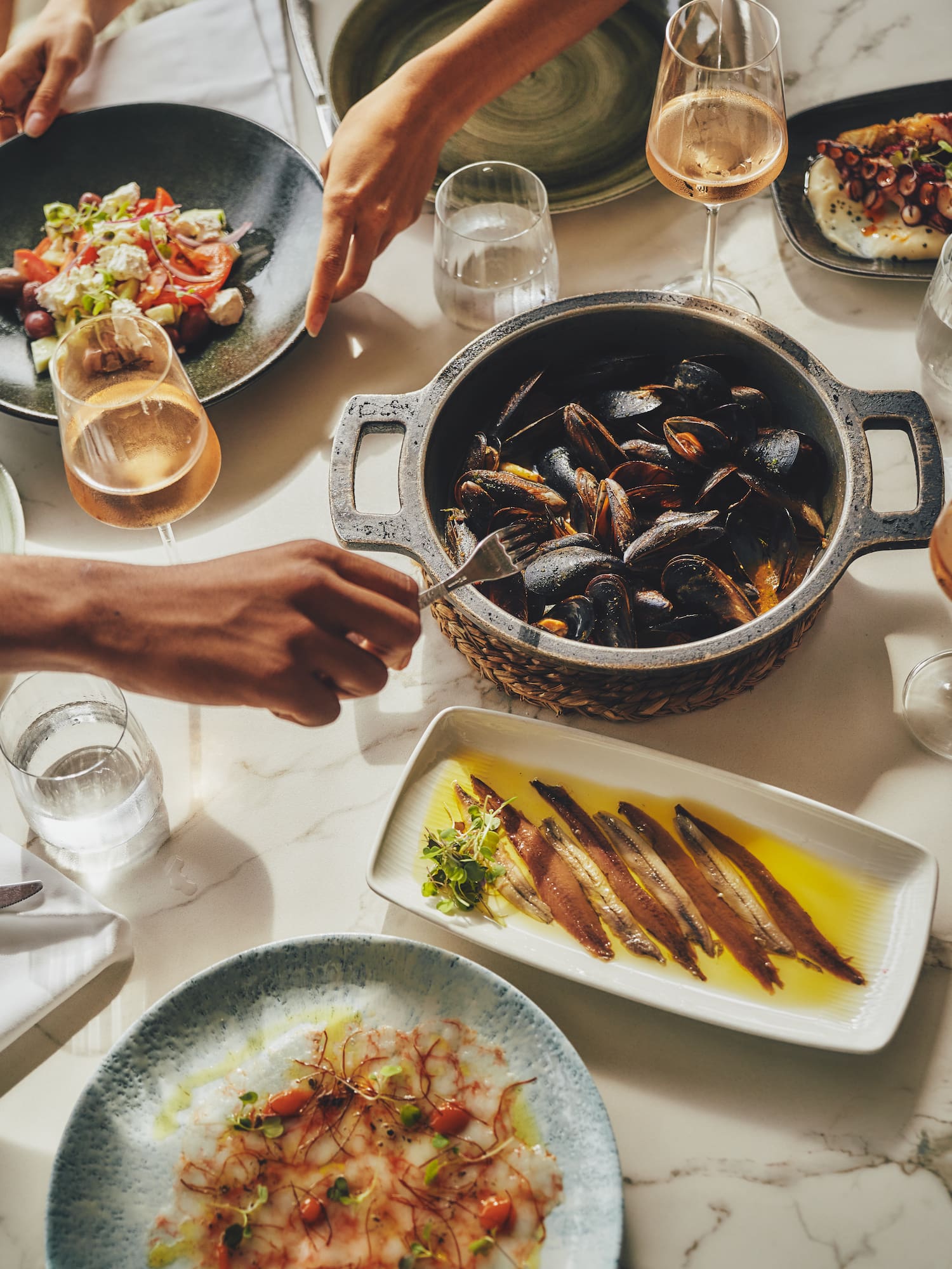 a table with plates of food and glasses of wine