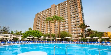 a large building with a pool and palm trees