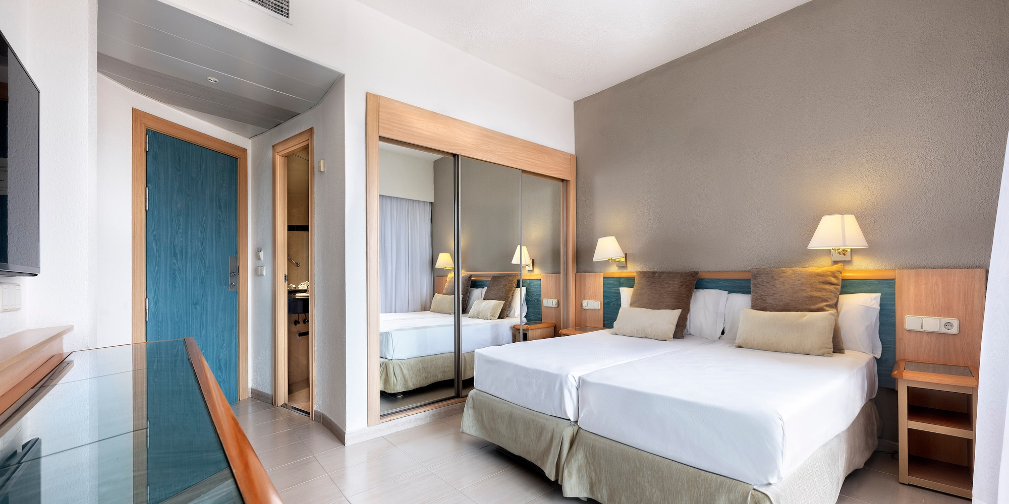 a room with two beds and a mirror