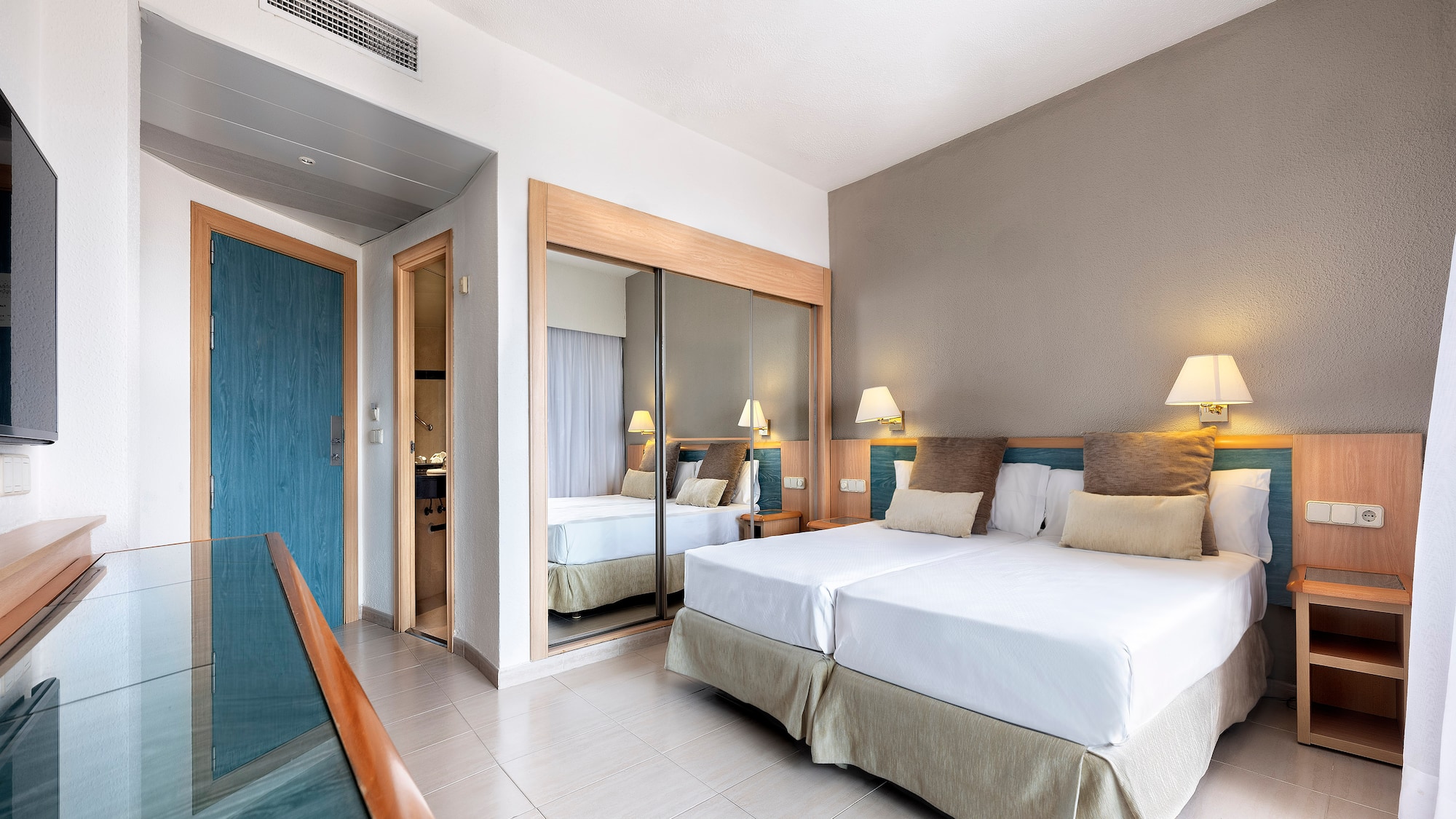 a room with two beds and a mirror