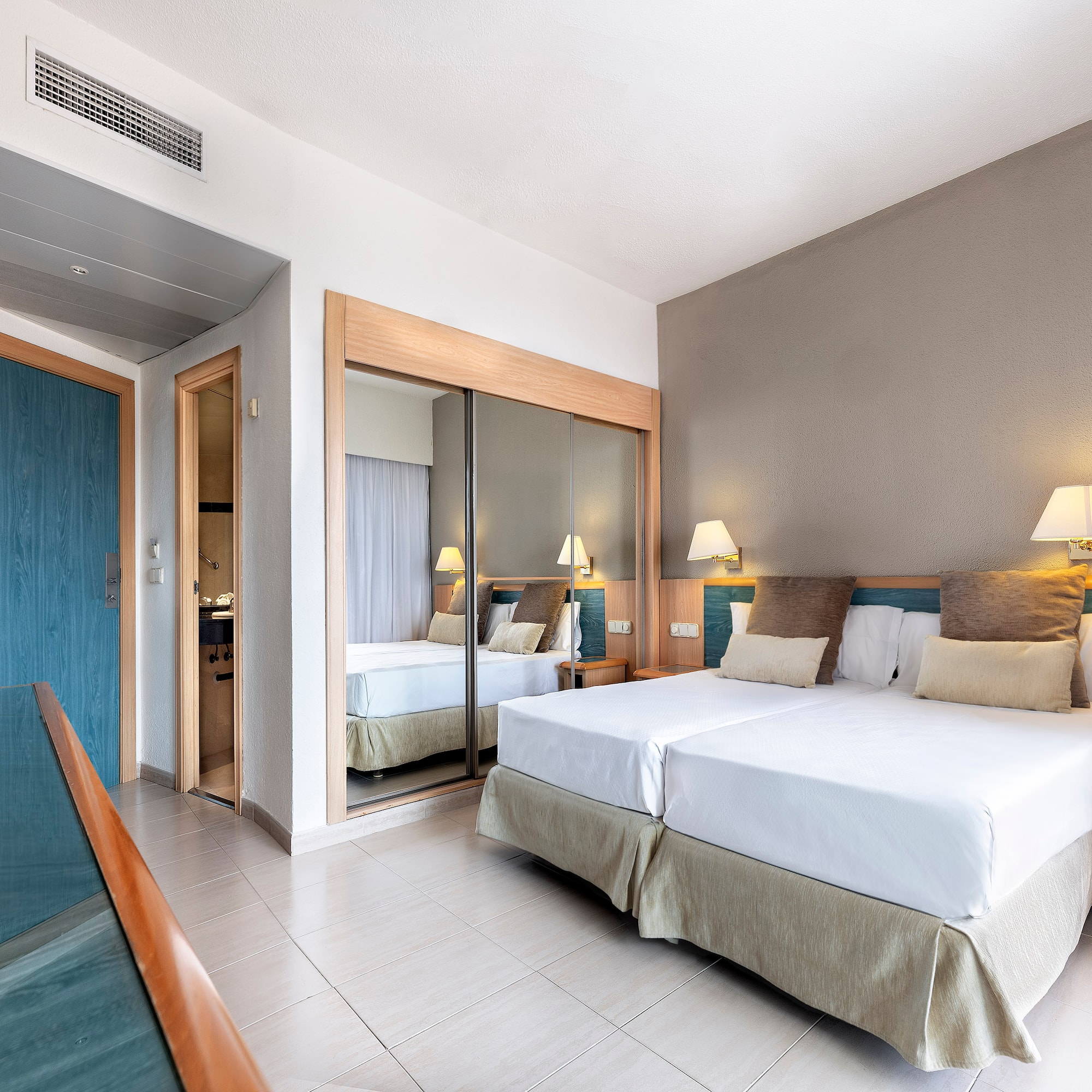 a room with two beds and a mirror