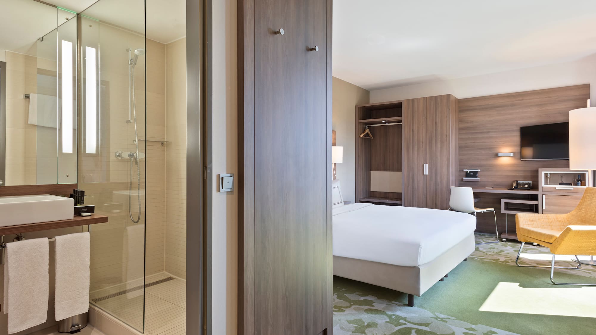 a room with a bed and a glass shower