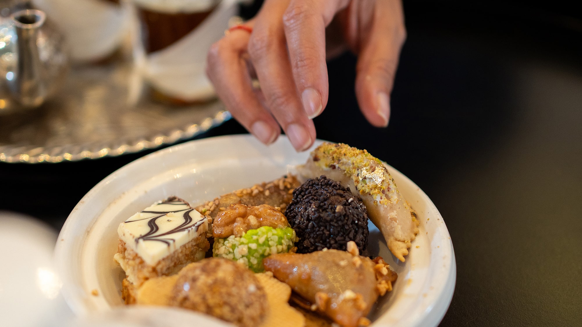 a hand reaching for food in a bowl
