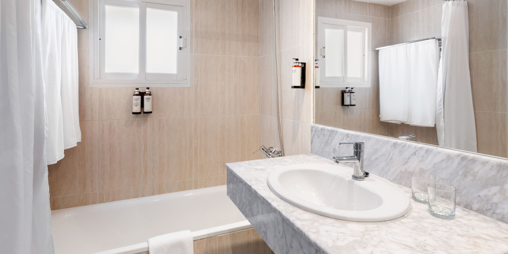 a bathroom with a marble countertop sink and bathtub