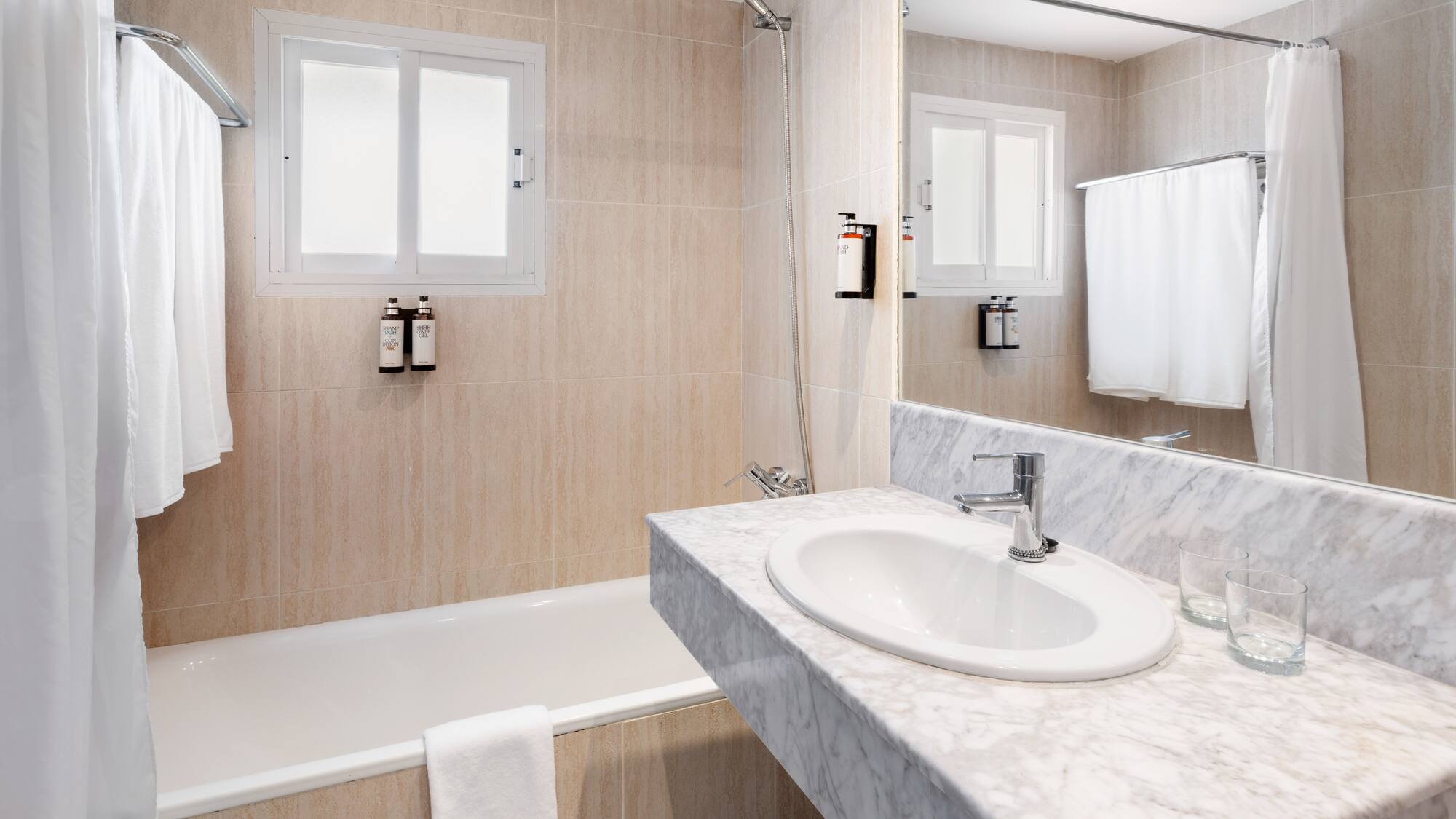 a bathroom with a marble countertop sink and bathtub