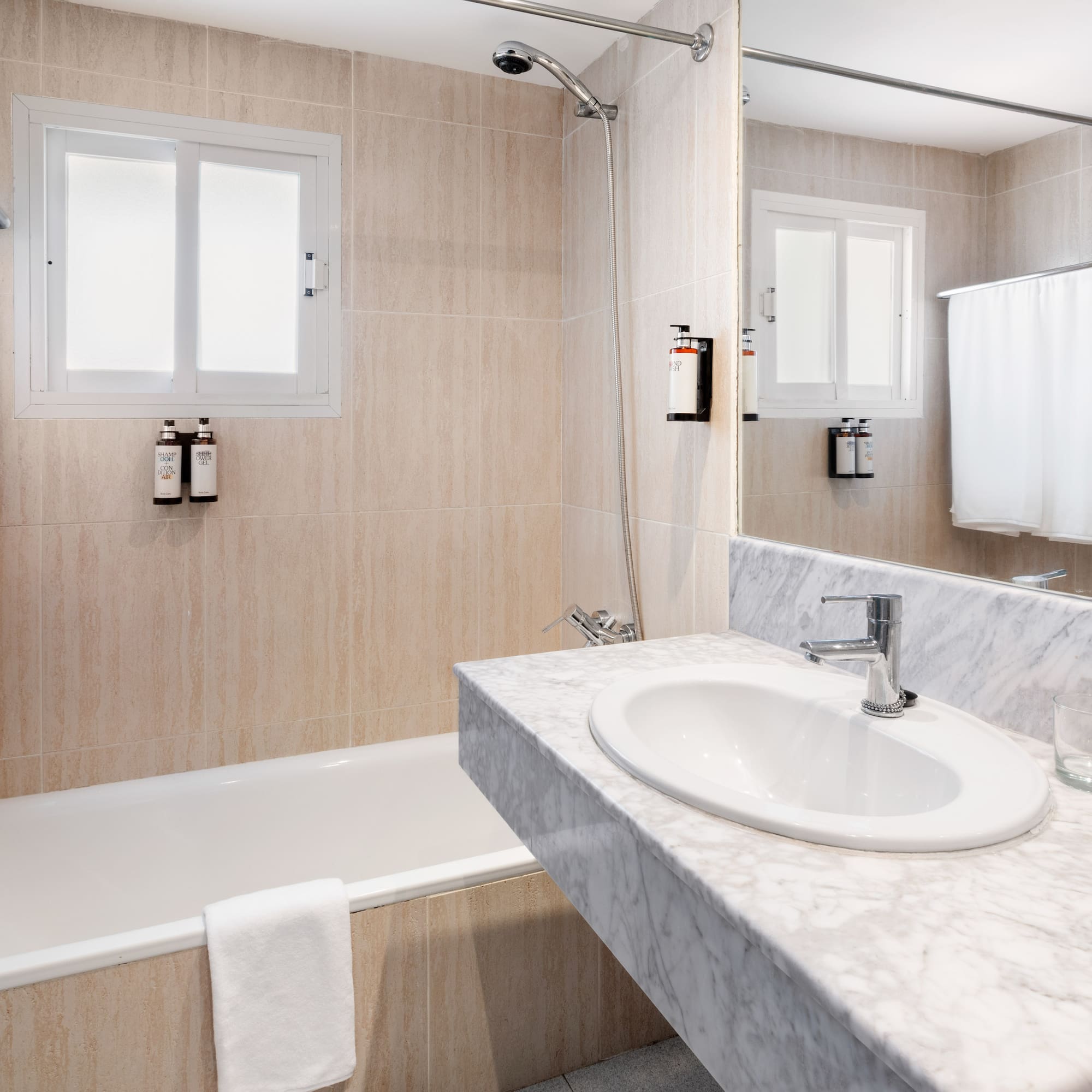 a bathroom with a marble countertop sink and bathtub