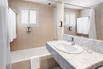 a bathroom with a marble countertop sink and bathtub
