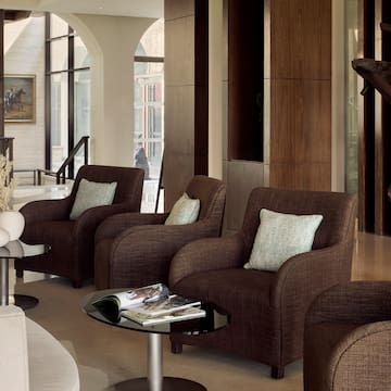 a room with brown chairs and a glass table