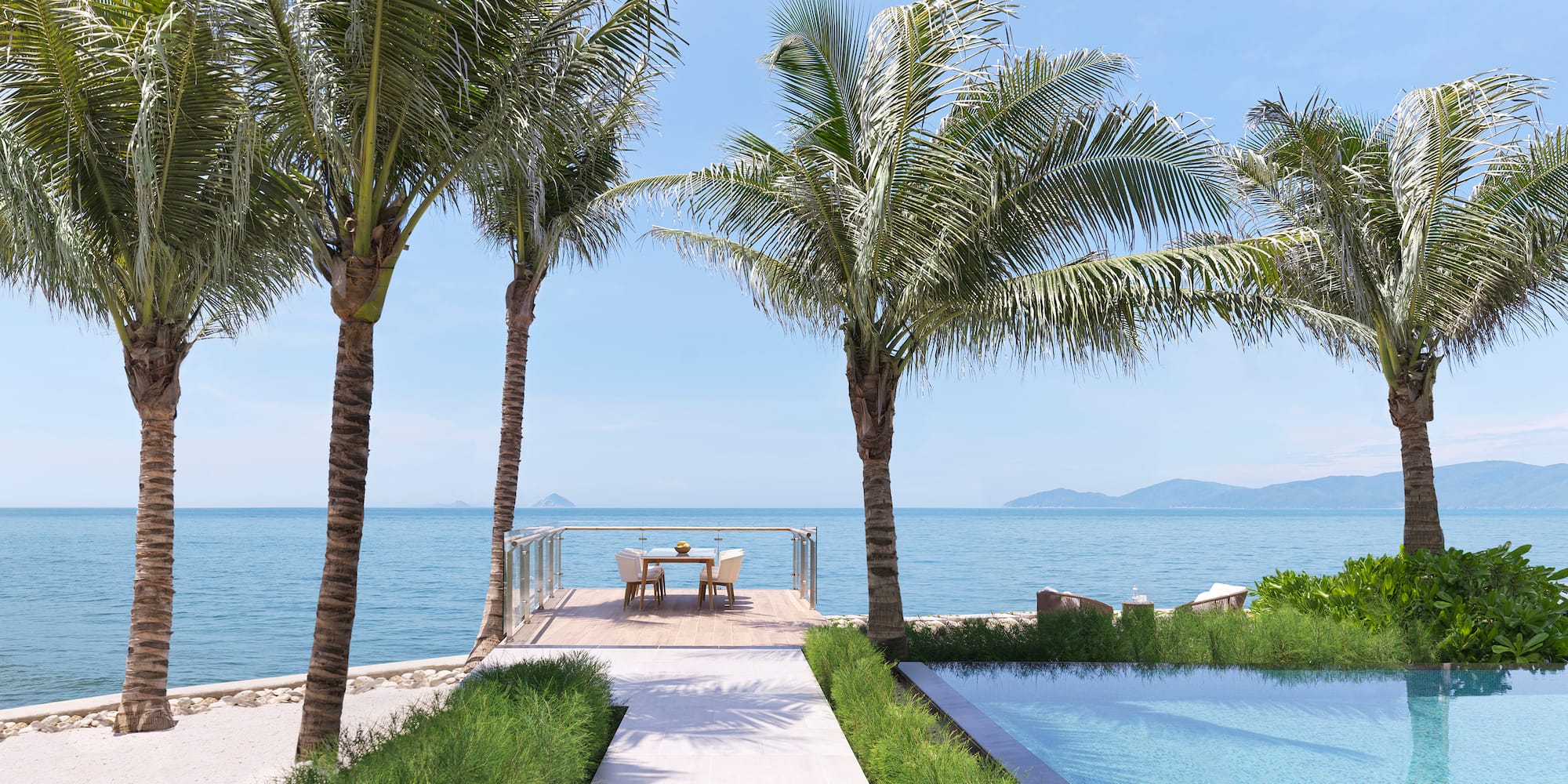 a deck with a table and chairs and a pool with palm trees