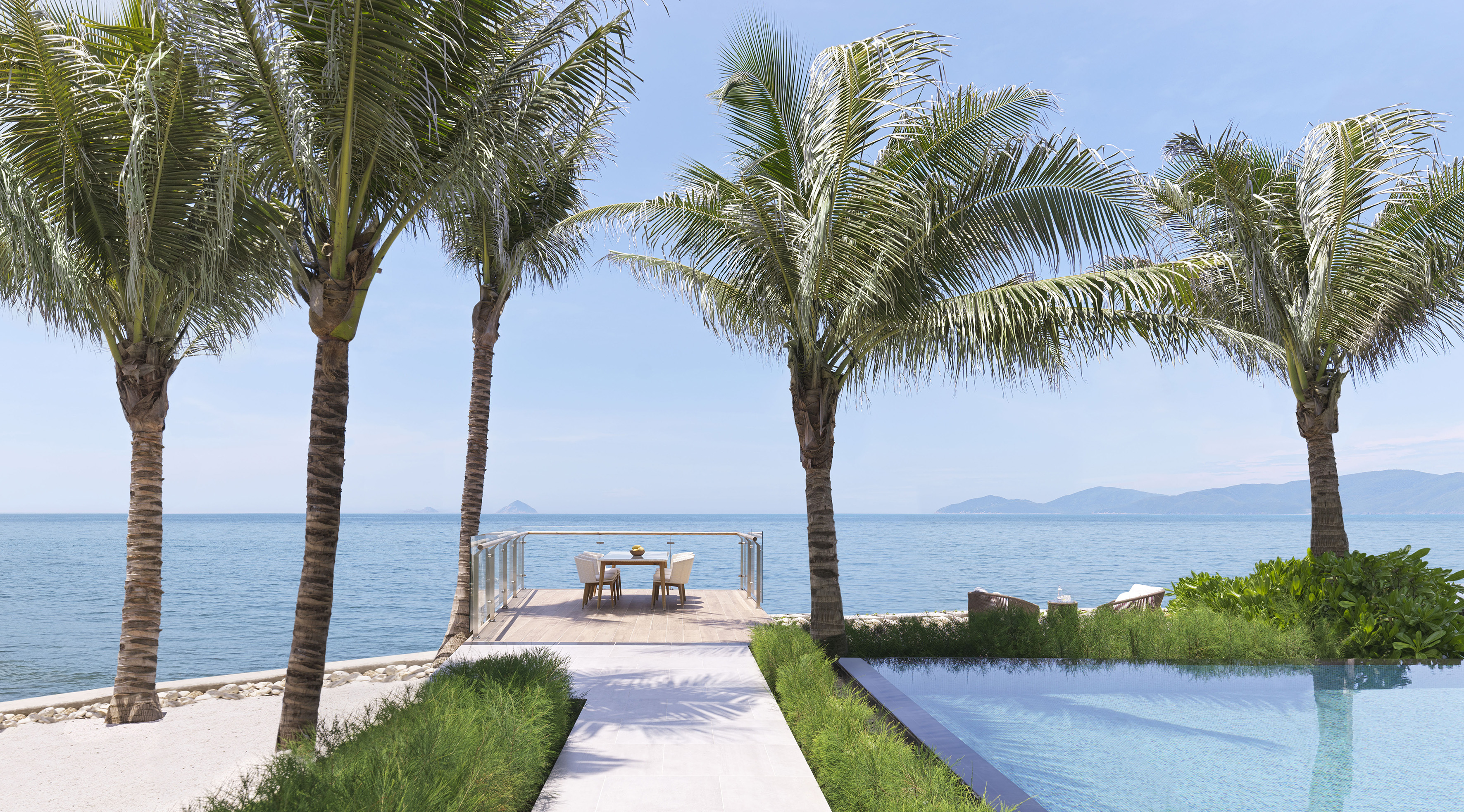 Tropical ocean view with palm trees, private dining deck, and infinity pool.