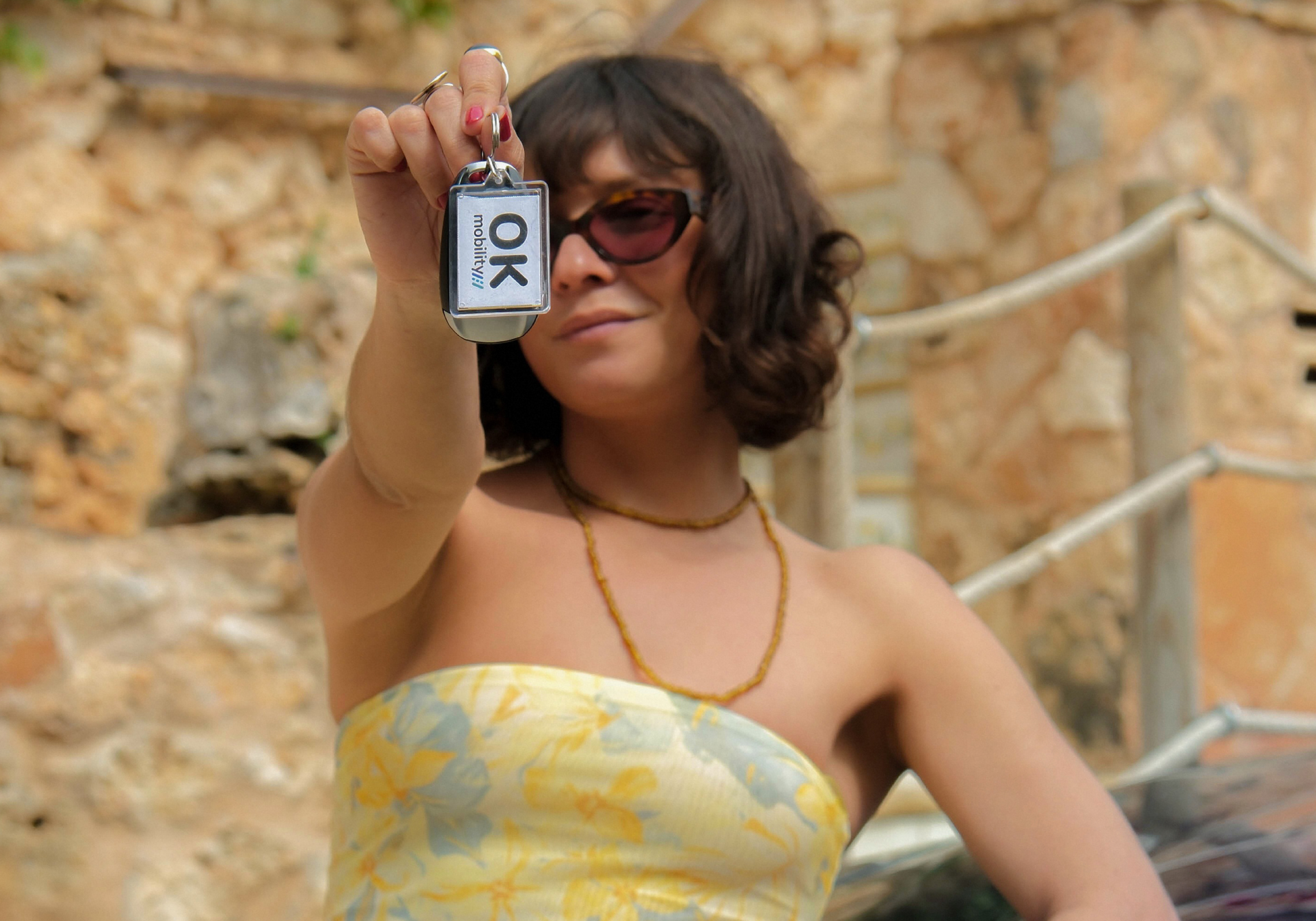 a woman holding up a keychain