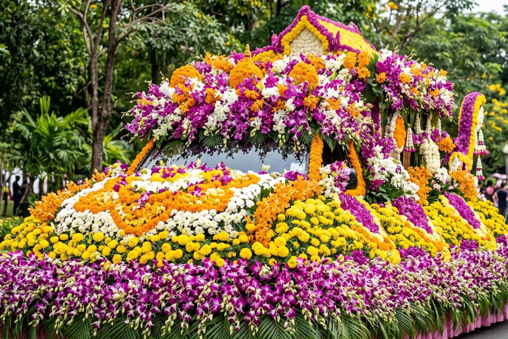 Festival flower float adorned with vibrant purple orchids and yellow marigolds.