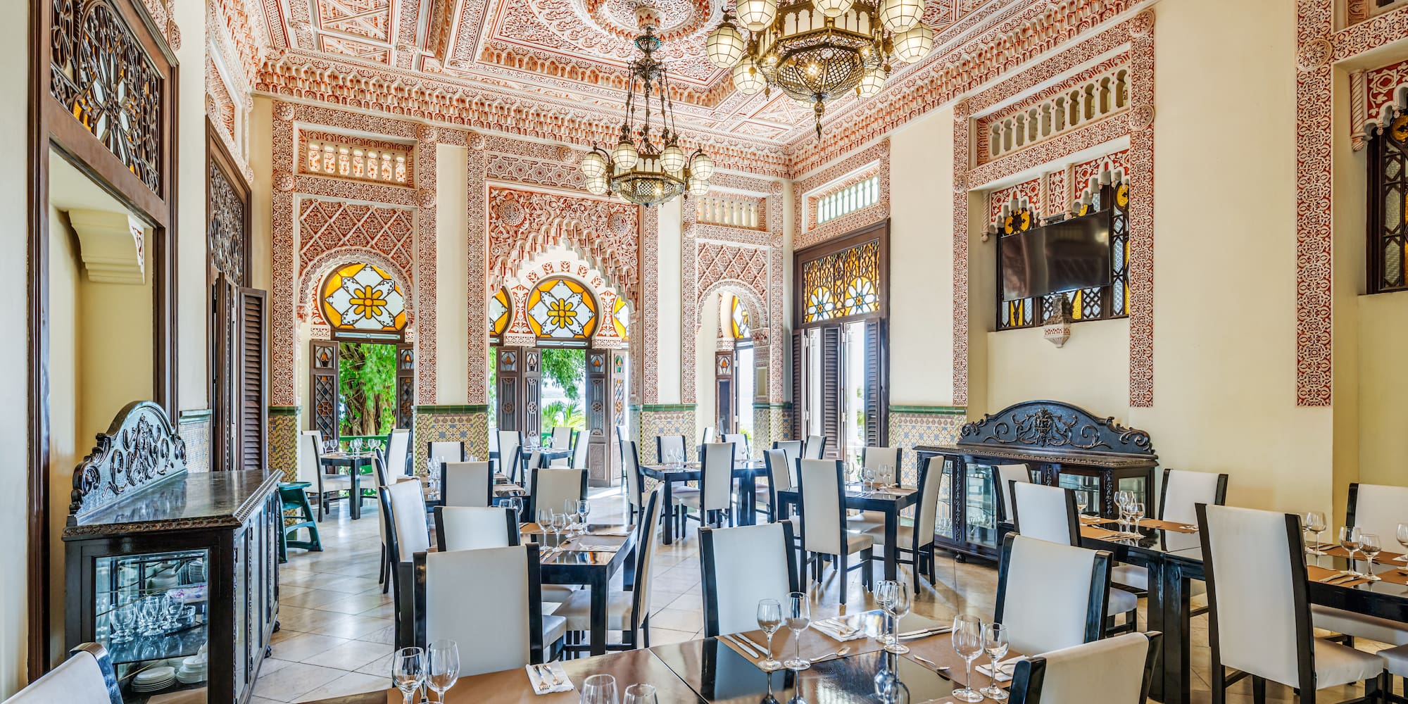 a room with ornate walls and tables and chairs